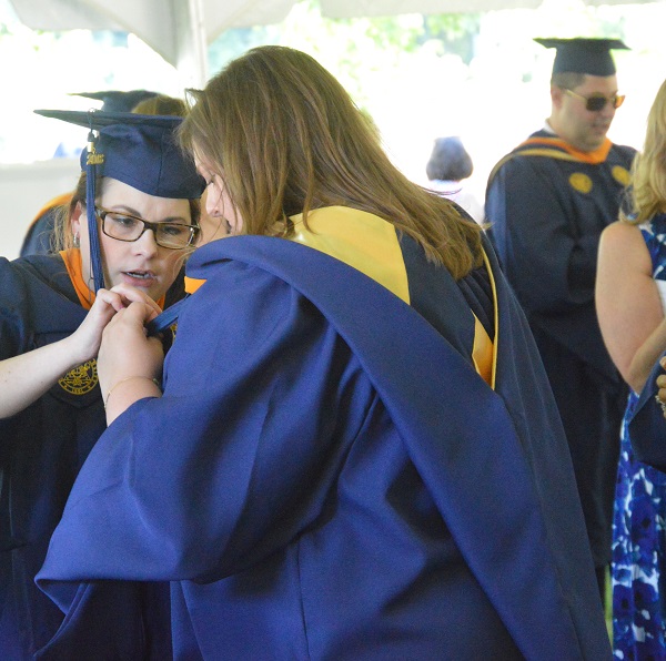 Two female students robing for commencement 2018